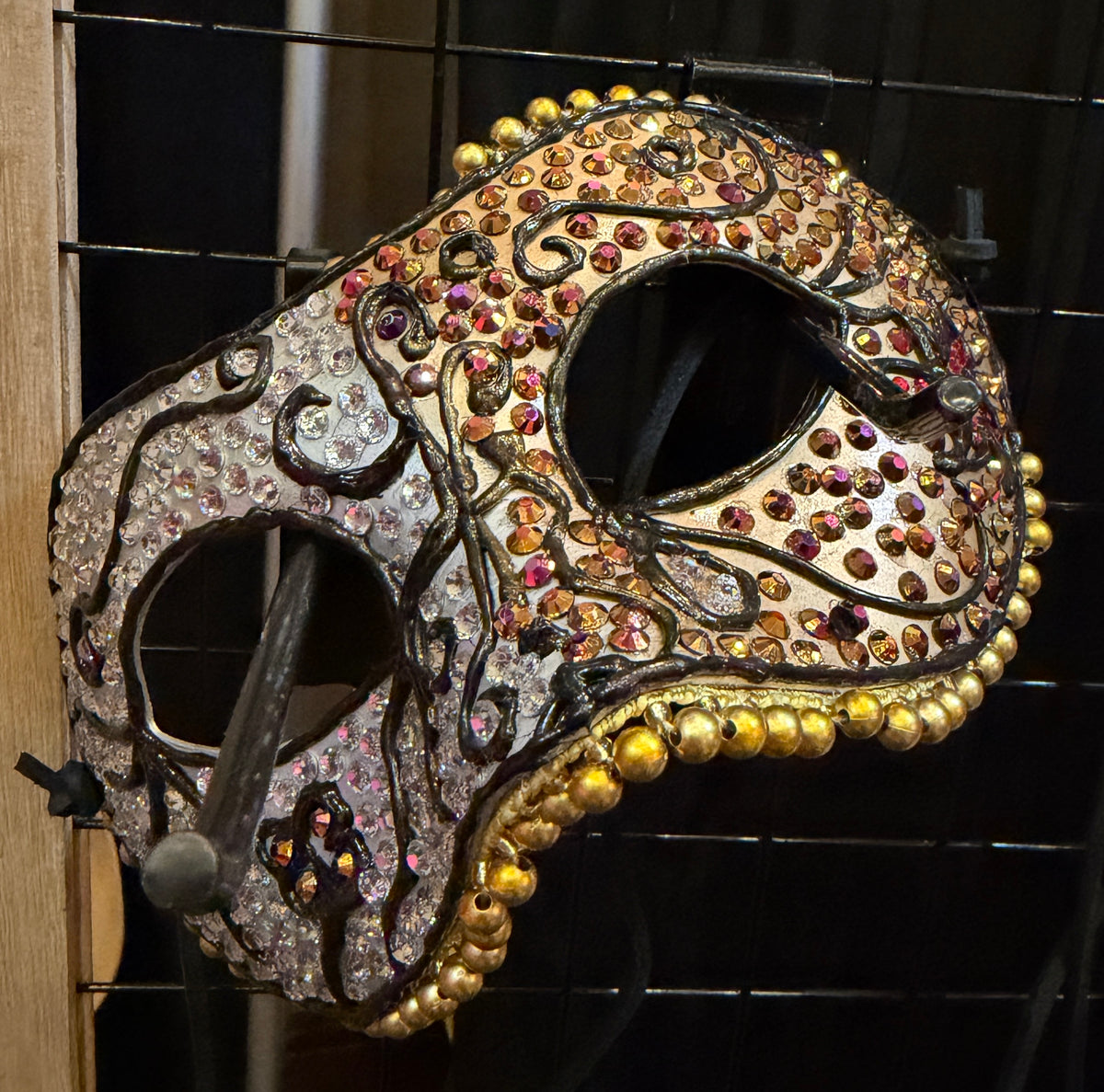 Decorative mask with gemstones on a dark background